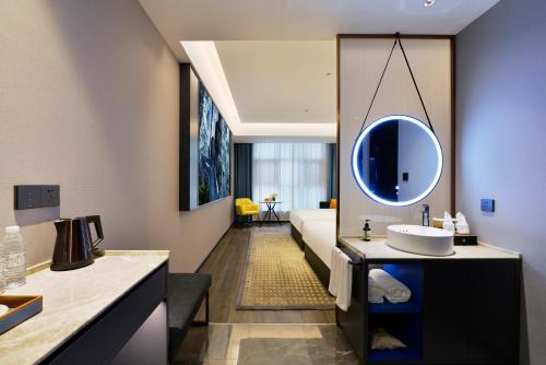 un bagno con lavandino e specchio di Mehood Hotel Hanzhong Central Plaza ad Hanzhong