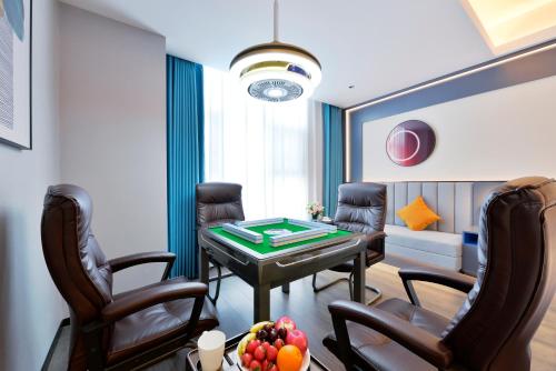 a room with a ping pong table and chairs at Mehood Hotel Hanzhong Central Plaza in Hanzhong