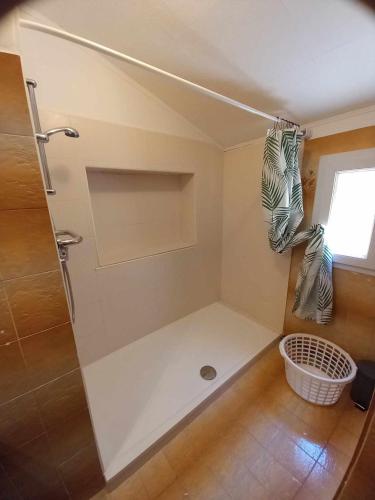 La petite salle de bains est pourvue d'une douche et d'une fenêtre. dans l'établissement Chambre d hôte les heures claires, à Istres