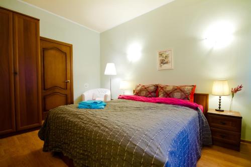 モスクワにあるLakshmi Apartment Krasnye Vorotaのベッドルーム1室(赤と青のシーツが備わる大型ベッド1台付)