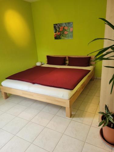 a bed in a room with a green wall at Gelbes Haus Heldritt in Bad Rodach