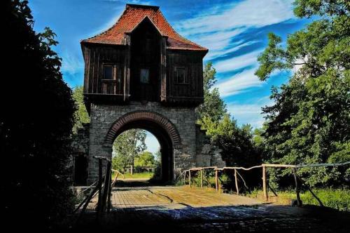 a building with an arch with a house on top of it at Pałac Krobielowice in Kąty Wrocławskie