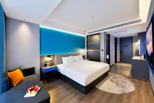 a hotel room with a bed and a couch at Mehood Hotel Hanzhong Central Plaza in Hanzhong