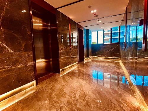 a lobby with a shiny floor and a glass wall at Platinum Coast Hotel and condominium 