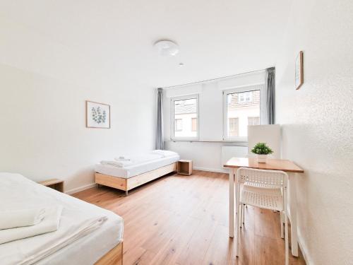 Cette chambre blanche comprend un lit et une table. dans l'établissement RAJ Living - 4 Zimmer Wohnung - 25 Min zur Messe DUS, à Krefeld