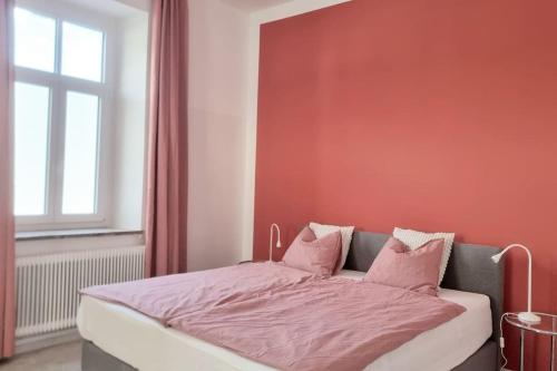 a bed with pink sheets in a room with a window at Apartment Charlotte - Feistritz an der Drau in Feistritz an der Drau