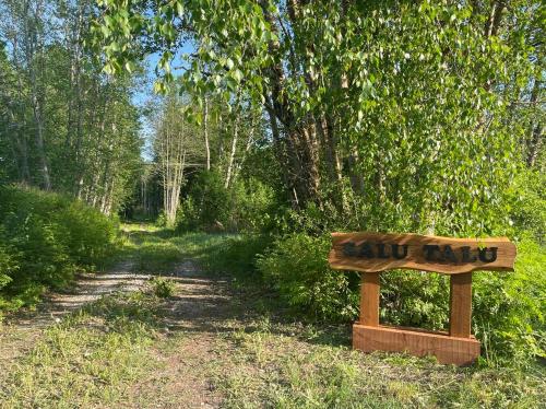 a wooden sign in the middle of a trail at Salu summer cottage in Vadi