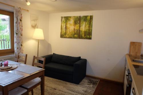 a living room with a couch and a table and a painting at Am Jenbach in Bad Feilnbach