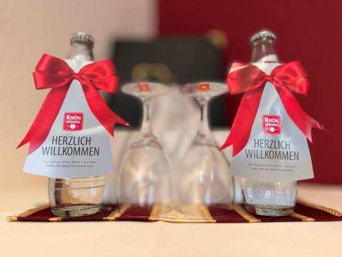 two bottles of water with red bows on a table at Hotel & Café Schachtenburg in Schlitz