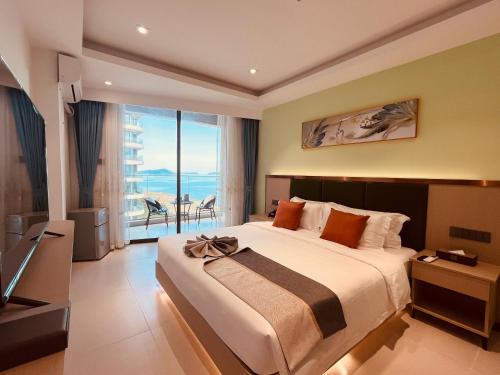 um quarto com uma cama grande e uma varanda em Platinum Coast Hotel and condominium 