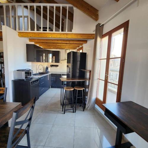 - une cuisine avec une table et quelques tabourets dans l'établissement Maison sur les toits confort, à Marseille