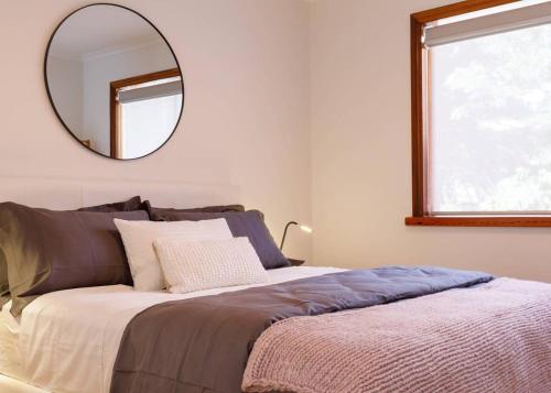 a bedroom with a large bed with a mirror on the wall at 2 Bdrm Apt in Annandale with Courtyard & Parking in Sydney
