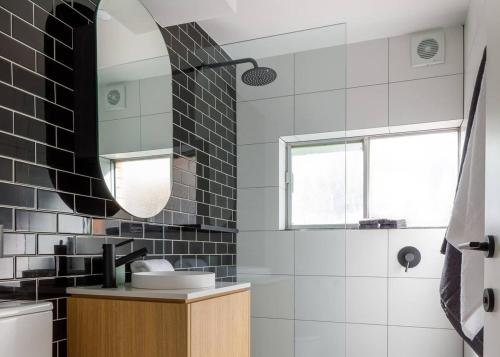 a bathroom with black and white tiles and a mirror at 2 Bdrm Apt in Annandale with Courtyard & Parking in Sydney
