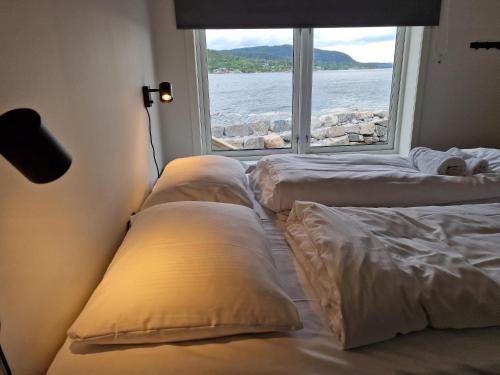 Zimmer mit 3 Kissen auf einem Bett mit Fenster in der Unterkunft Preikestolen Panorama in Strand