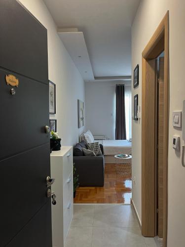 a hallway leading to a living room with a bed at Apartman Malena in Trebinje