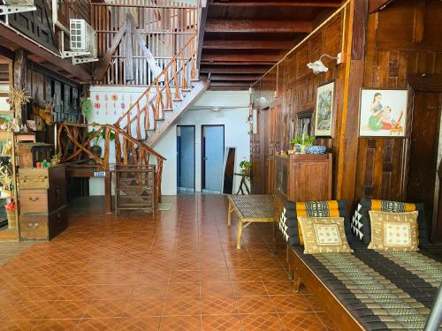 a living room with a staircase and a couch at Banthai Guesthouse in Phetchaburi