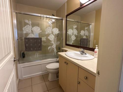 Un baño con inodoro, lavabo y ducha. en Victory House, en Burnaby