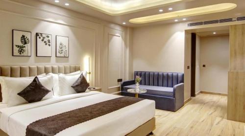 a bedroom with a large bed and a couch at HOTEL AIRPORT PALACE in New Delhi