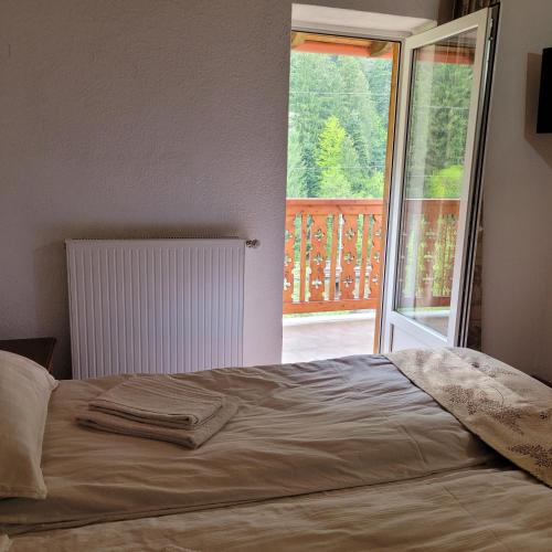 a bedroom with a bed and a window with a balcony at Natura Tusnad in Băile Tuşnad