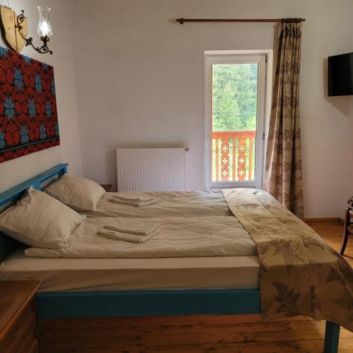 a bed in a room with a window at Natura Tusnad in Băile Tuşnad