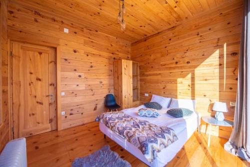 a bedroom with a bed in a wooden cabin at Ideal six-person villa for large families with pets, featuring barbecue and spacious yard Svaneti Сountryside 1 in Shkaleri