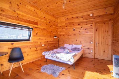 a bedroom with a bed in a log cabin at Ideal six-person villa for large families with pets, featuring barbecue and spacious yard Svaneti Сountryside 1 in Shkaleri