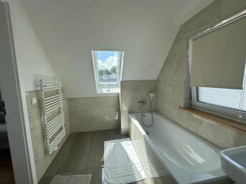 a bathroom with a bath tub and a sink at Haus Güldengossaer in Leipzig
