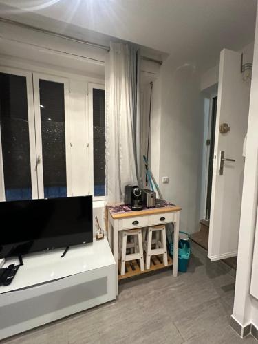 un salon avec une télévision et une table dans l'établissement Charmant studio, à La Colle-sur-Loup