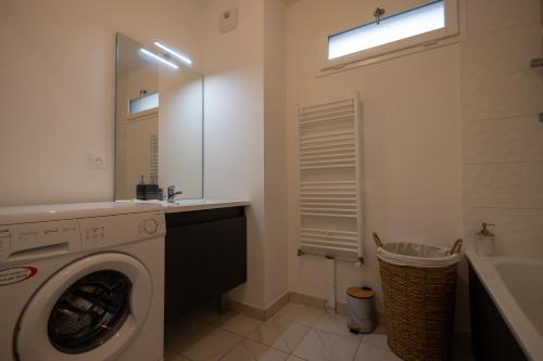 uma casa de banho com uma máquina de lavar roupa e um lavatório em DUPLEX Luxury-Appart - DYSNEY LAND PARIS em Bussy-Saint-Georges