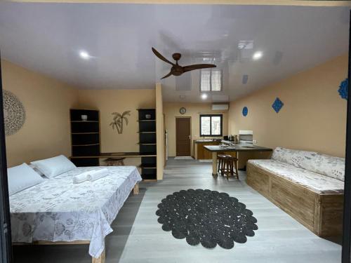 a bedroom with a bed and a couch and a table at PUNA Lodge in Atiue