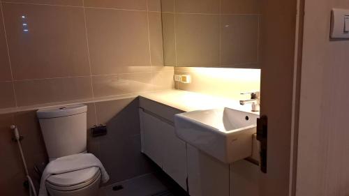 a bathroom with a white toilet and a sink at LIV@5 Condominium in Makkasan