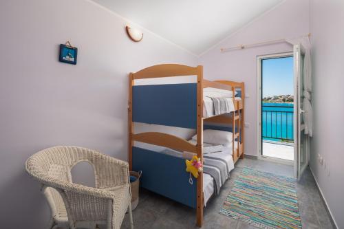 ein Schlafzimmer mit einem Etagenbett und einem Stuhl in der Unterkunft Villa Gajeta in Sevid