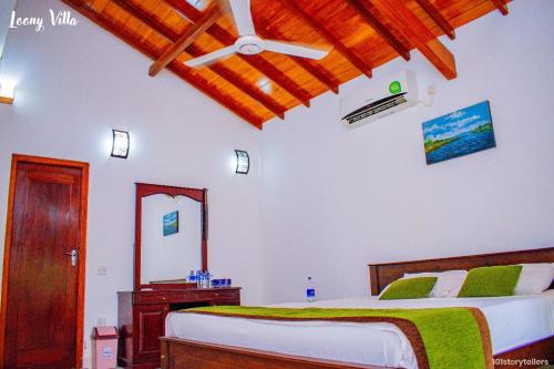a bedroom with a bed and a wooden ceiling at Loony Villa in Negombo