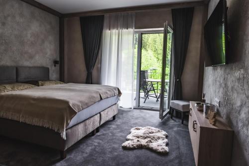 um quarto com uma cama e uma porta de vidro deslizante em Luxusní apartmán Domovjanka - MEDVĚDÍN em Bílá