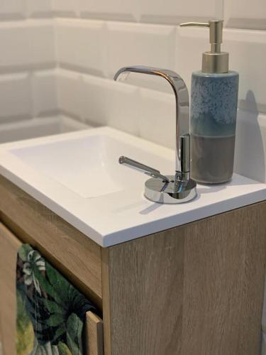 La salle de bains est pourvue d'un lavabo et d'un robinet. dans l'établissement Le Cottage de Valérie, à Entzheim