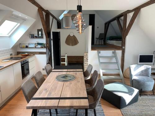 une cuisine et une salle à manger avec une table et des chaises en bois dans l'établissement Le Cottage de Valérie, à Entzheim