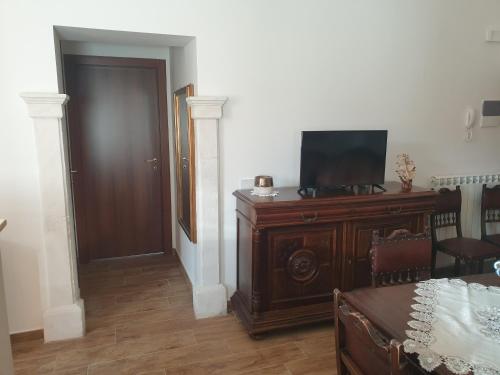 a living room with a television on a wooden dresser at Le Rondinelle in San Demetrio neʼ Vestini