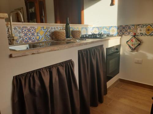 a kitchen counter with a sink and a stove at Le Rondinelle in San Demetrio neʼ Vestini