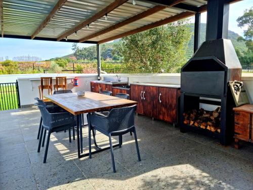 a outdoor kitchen with a table and a grill at Klawerjas in Robertson
