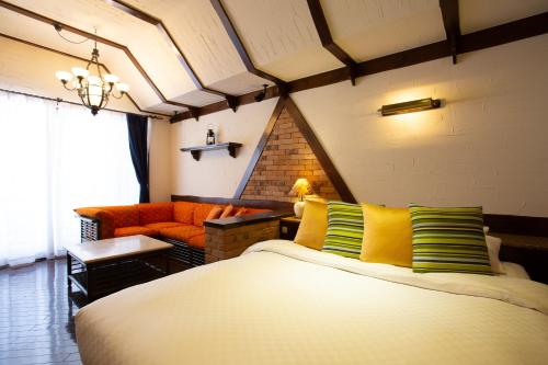 1 dormitorio con 1 cama con almohadas amarillas y verdes en LCO-Resort, en Takizawa