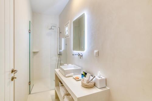 a white bathroom with a sink and a shower at Villa Bellonia in Naousa