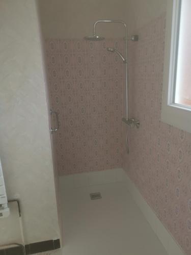 une salle de bain avec une douche avec une porte vitrée dans l'établissement le pavillon a la campagne, à La Perche