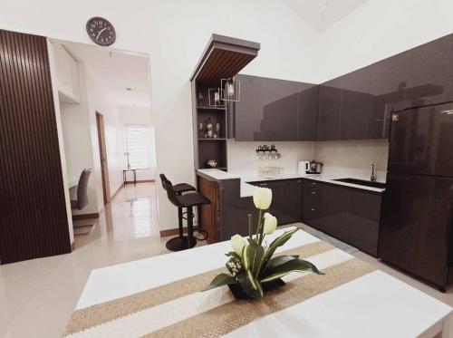 a kitchen with black cabinets and a table with a plant at Cozy Family Home Rental in General Santos City in General Santos