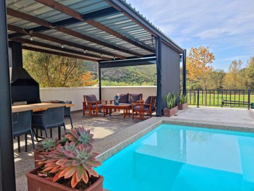 an outdoor patio with a pool and a table and chairs at Klawerjas in Robertson