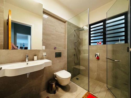 a bathroom with a toilet and a sink and a shower at Face a l'ocean et au Coin de mire in Pereybere