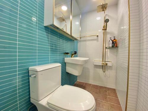 a bathroom with a toilet and a sink and blue tiles at Terrace House Hwagok station in Seoul