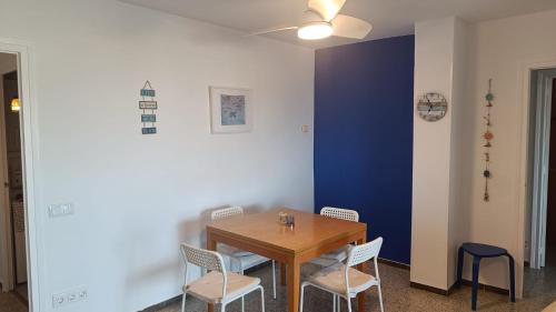 Canet playa y centro في كانيه دي مار: غرفة طعام مع طاولة وكراسي خشبية