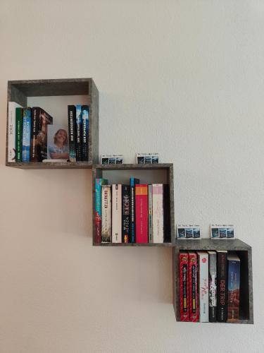 a book shelf on a wall with books at Ferienwohnung Waldblick, nahe Jennersdorf und Therme in Windisch Minihof