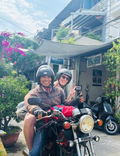 a man and a woman sitting on a motorcycle at Good Morning Hoi An Homestay and Hostel in Hoi An