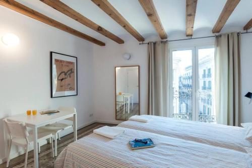 a bedroom with a bed and a table and a window at Central bcn verdete in Barcelona